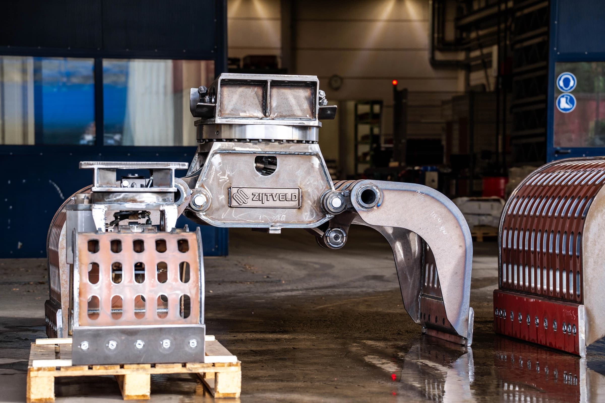 Blanke, ongelakte sorteergrijper in de fabriek naast schalen op een pallet