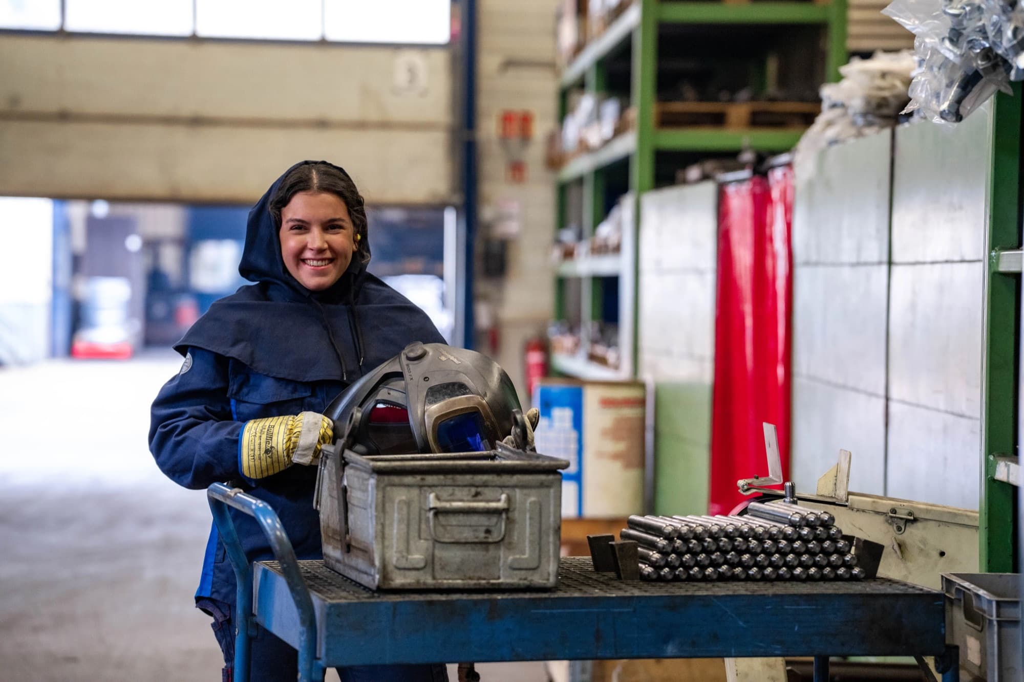 Lasser met laskap en gereedschapskist in de productiehal